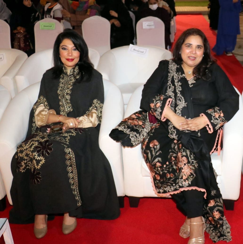 Shahmeen Islam seated with two guests at a ceremony