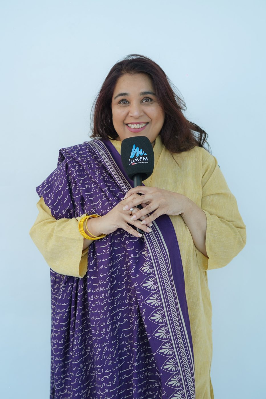 Shahmeen Islam holding a Live FM microphone
