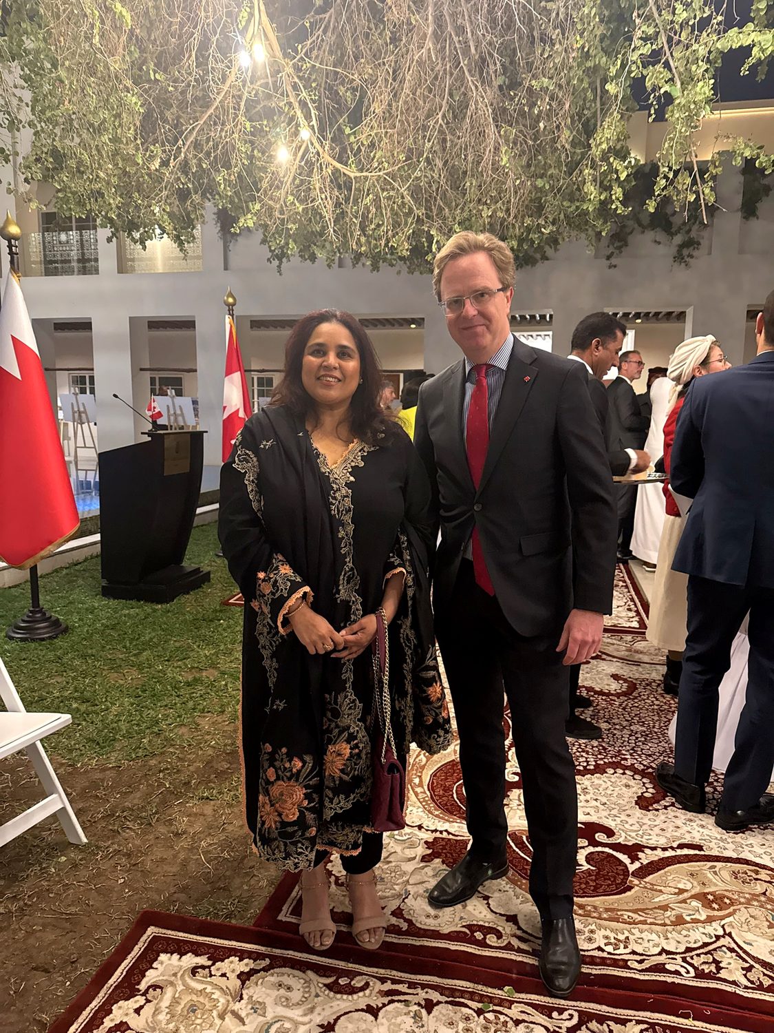 Shahmeen Islam with a man in a suit at an outdoor reception