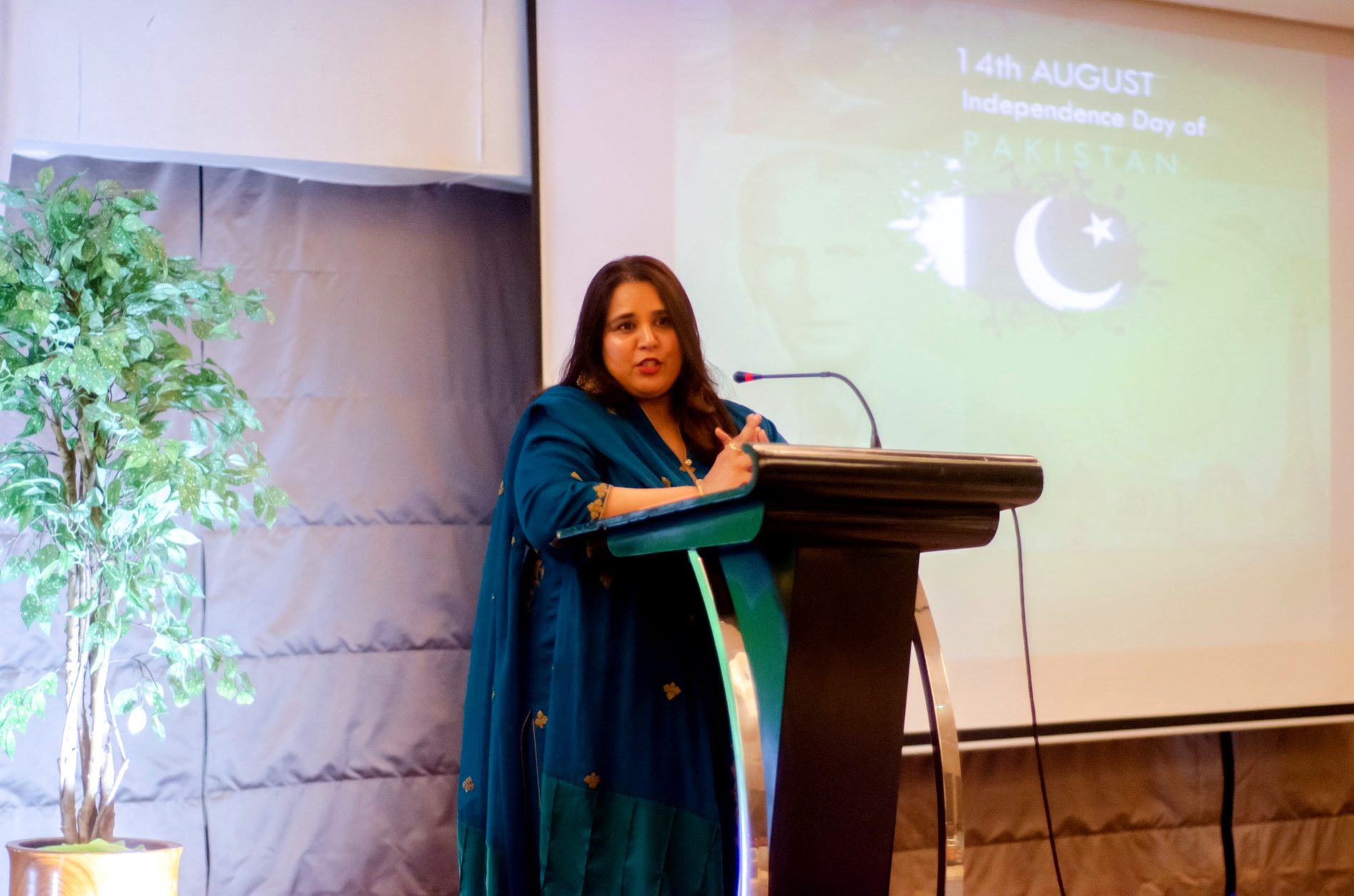 Shahmeen Islam speaking at a podium