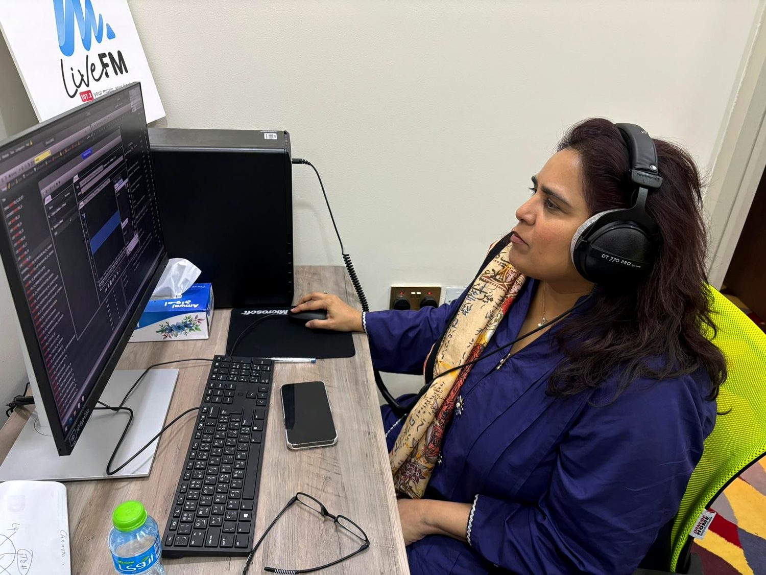 Shahmeen Islam wearing headphones at a studio desk