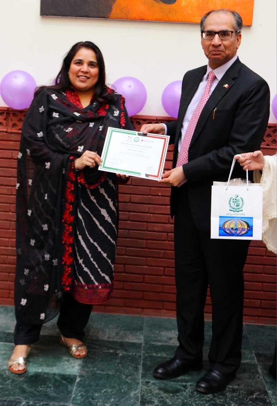 Shahmeen Islam being handed a framed certificate